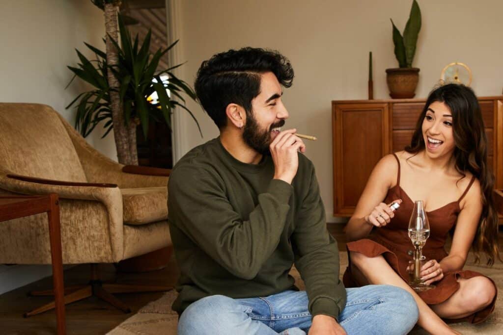 A guy and a girl smoking weed and laughing