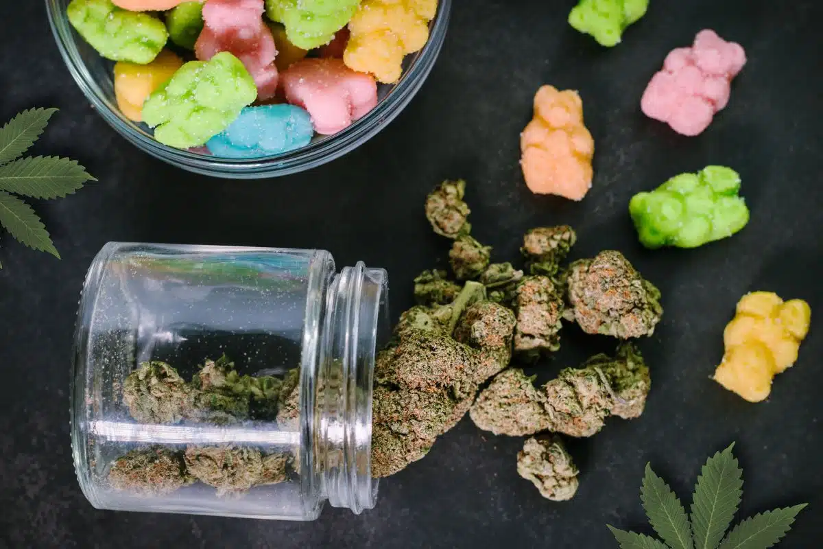 Gummy bears and marijuana-infused edibles in a glass jar.