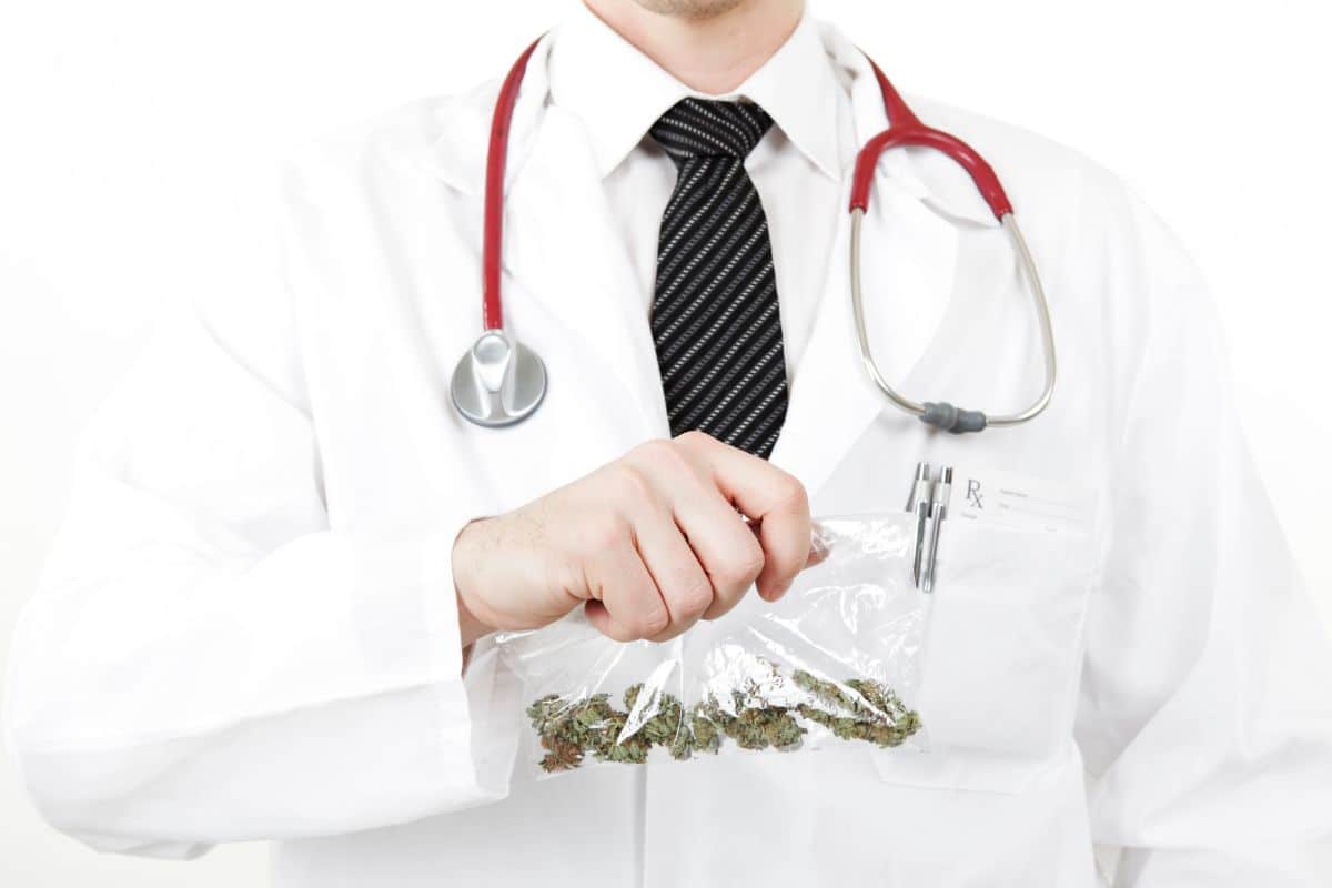 A doctor holding a packet of weed 