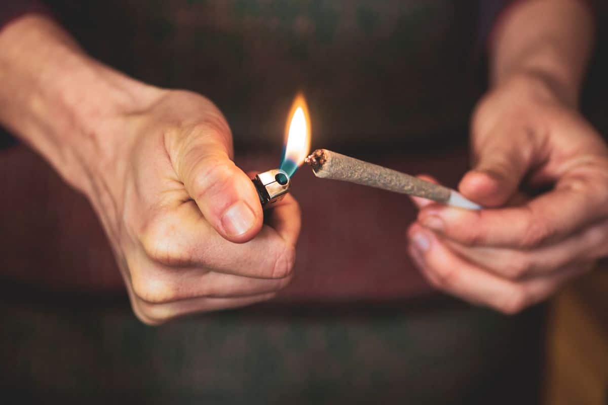 A man lighting up his pre roll