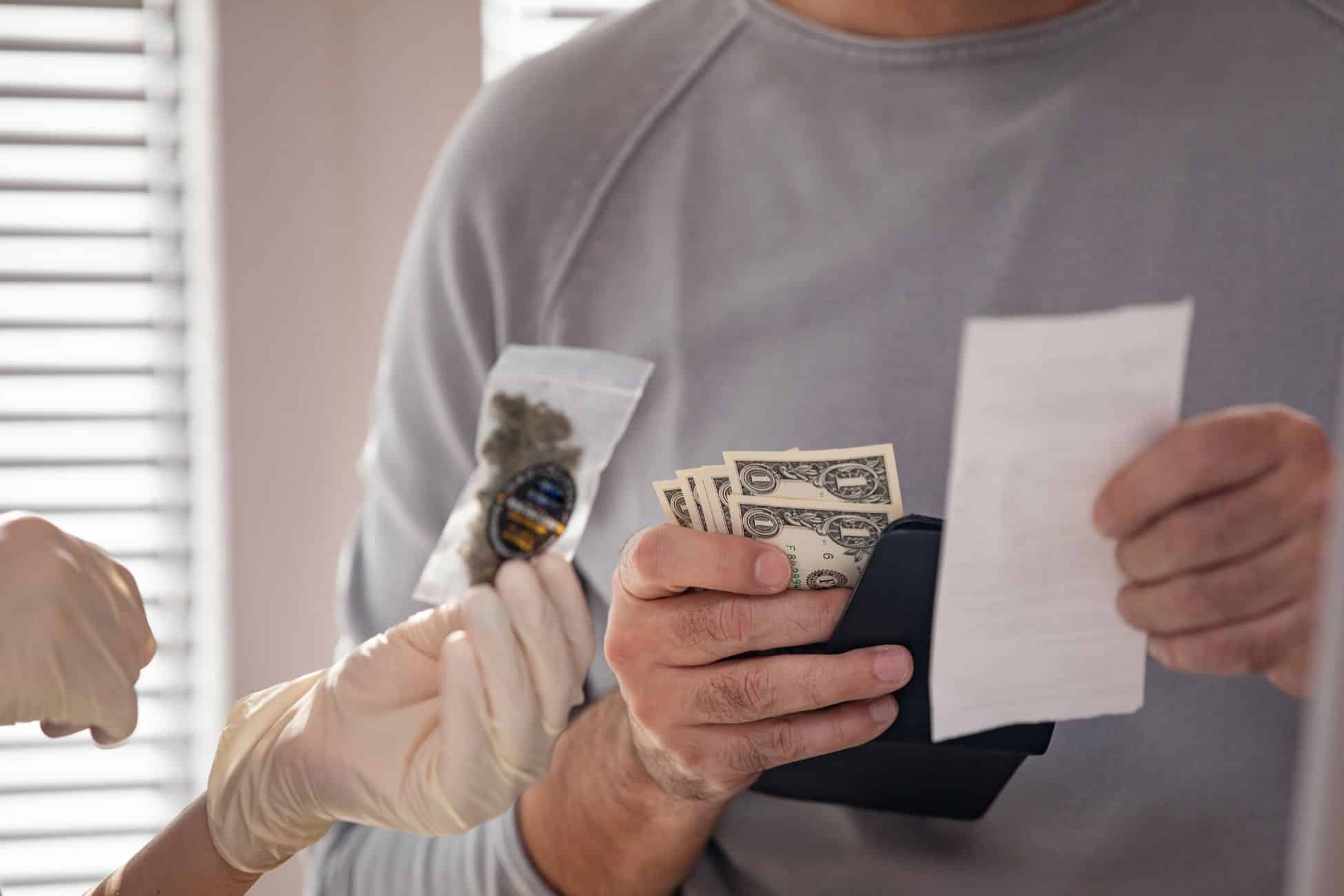A man is holding money while a woman is holding a check.