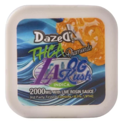 The image shows a blue and orange container of DazedA THCa Diamond Dabs LA OG Kush, featuring 2g with Live Rosin Sauce. This indica strain has 2000MG of product and under 0.3% THC, ideal for fans of THCa Diamond Dabs.