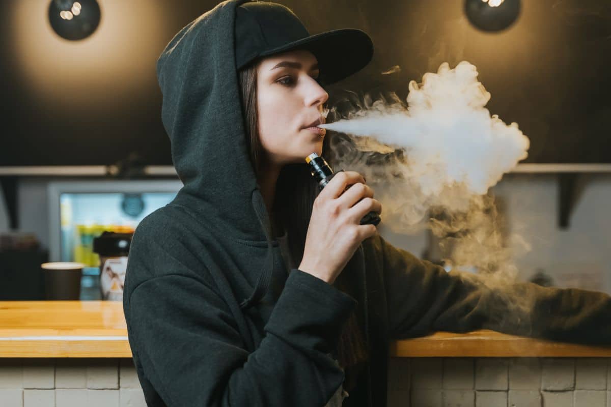 A lady vaping with weed budder concentrate inside the vape.