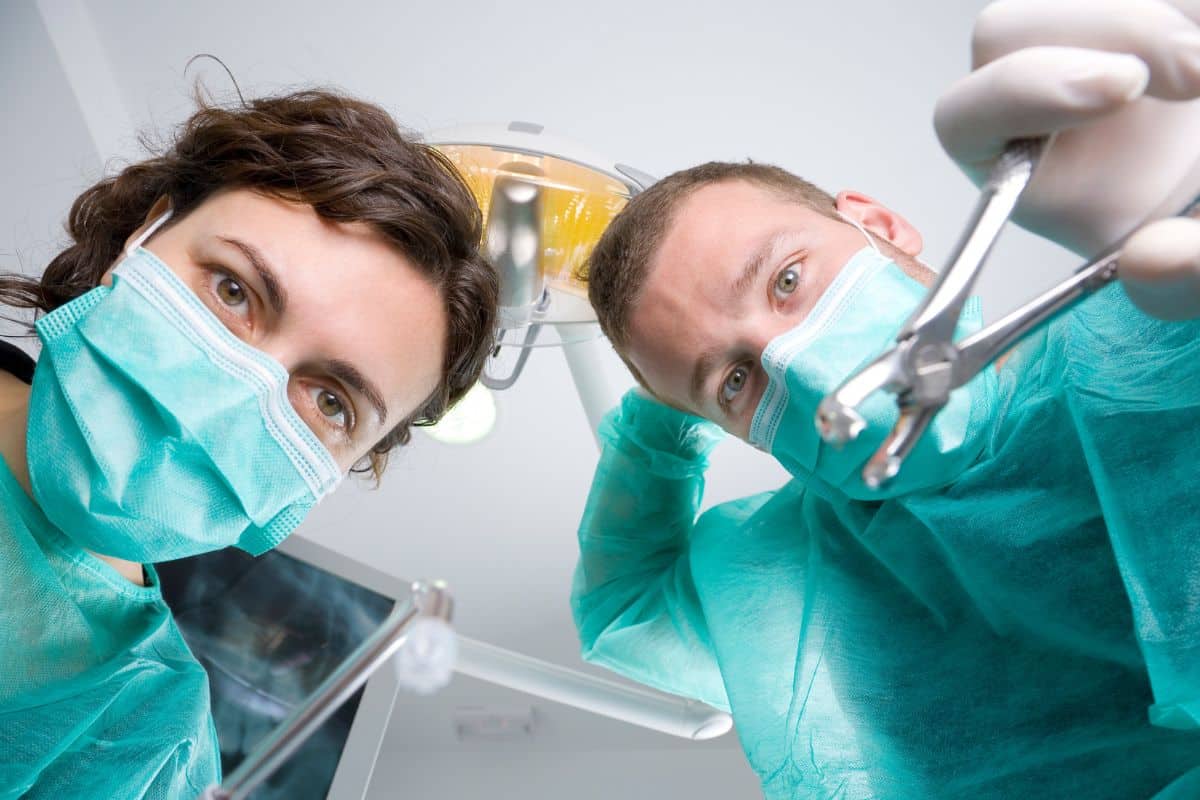 Doctor checking teeth after removing the wisdom tooth of patient.