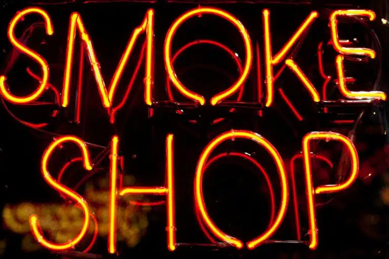 Red neon sign reading "smoke shop"