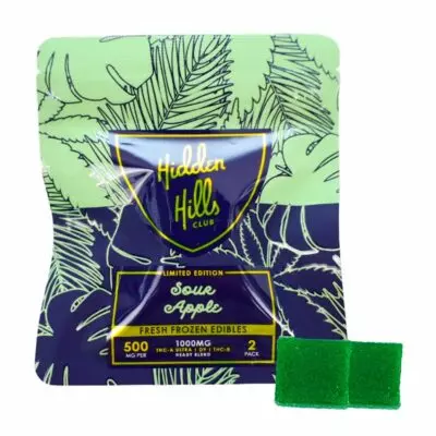 A package labeled "Hidden Hills Heady Blend Sour Apple" contains 500 mg THC. The package design features leafy patterns in green and blue. Two green square edibles are displayed beside it, offering a tantalizing hint of the potent 1000mg edibles experience within.