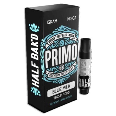 Image of a Half Bak'd Primo THC-P/CBD vape cartridge. The box displays "1GRAM INDICA" and the product is named "Blue Milk." The cartridge is positioned next to the box.