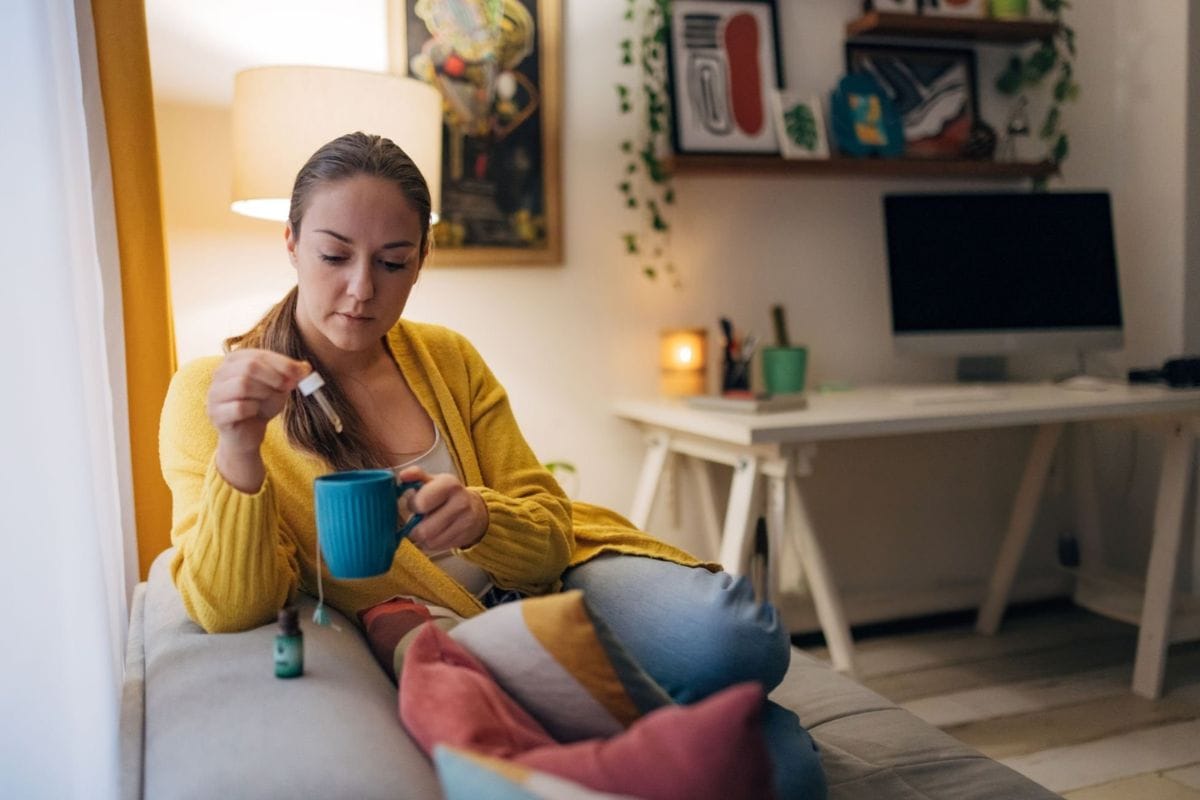 A lady is taking THC oil with tea for relaxation