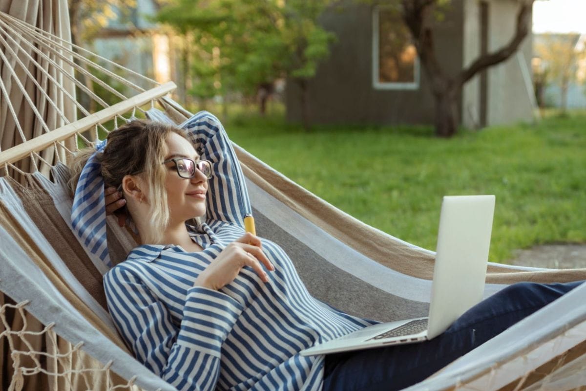 A woman relaxing outdoors while vaping THCA