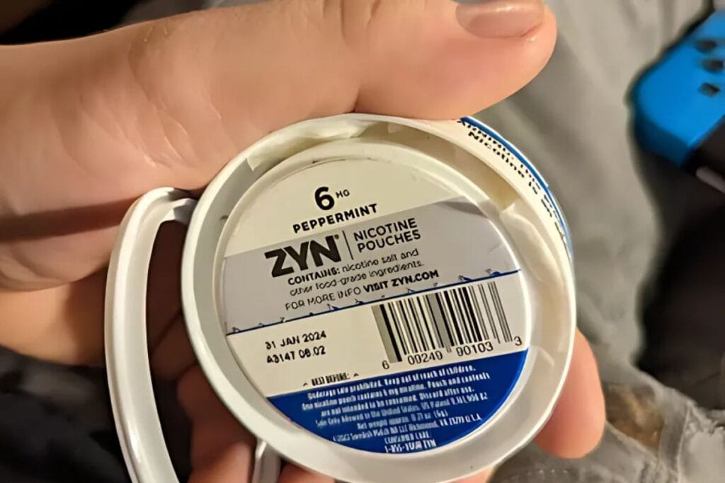 A person showing empty compartment of 
 zyn nicotine pack