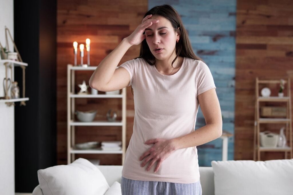 A woman experiencing nausea following excessive nicotine pouch consumption