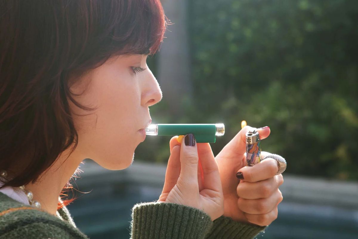 A lady smoking cannabis with the help of a one-hitter