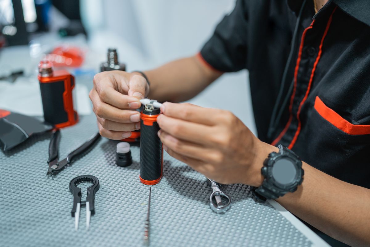 A person cleaning a vape cartridge and its parts