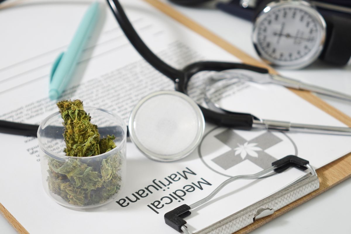 A medical marijuana certificate is kept alongside marijuana in a bottle and other medical equipment