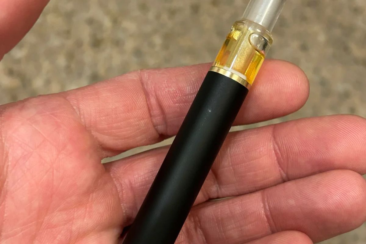 A person holding clogged disposable vape