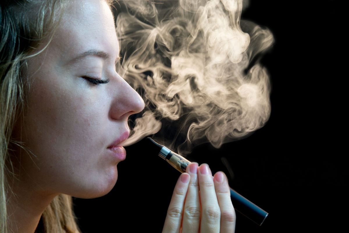 A lady is slowly vaping Delta-9 THC